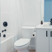 Victoria apartment for rent - A white toilet sits next to a white sink in a bathroom.