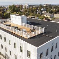 Victoria apartment for rent - A white building with a flat roof and a balcony.
