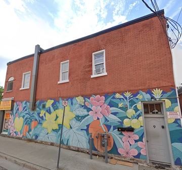 Kitchener apartment for rent - A red brick building with a mural of flowers painted on the side.