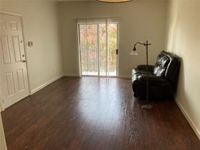 Austin apartment for rent - A black leather chair sits in a room with a wooden floor and a sliding glass door.