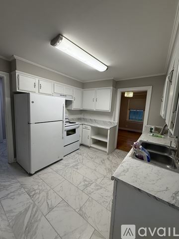 Jackson house for rent - A black refrigerator stands in a kitchen with green cabinets.