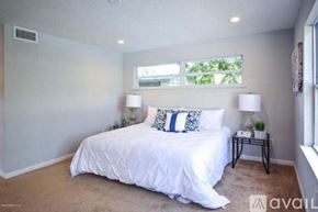 Jacksonville house for rent - A bedroom with a large bed and two lamps.