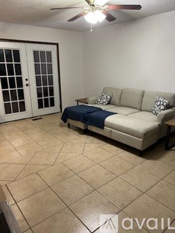 Oklahoma City house for rent - A living room with a couch and a fan.
