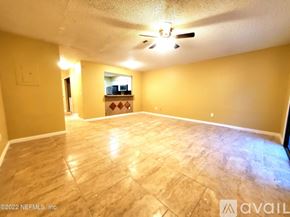 Jacksonville townhouse for rent - A spacious room with a ceiling fan and a wooden floor.