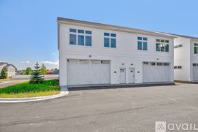 North Mankato townhouse for rent - A large white building with a garage door is in the foreground.