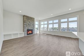 North Mankato townhouse for rent - A spacious room with a stone fireplace and large windows.
