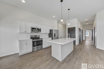North Mankato townhouse for rent - A modern kitchen with white cabinets and a central island.