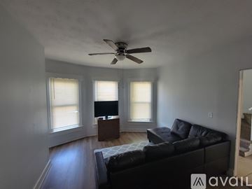 Dayton house for rent - A living room with a black couch and a ceiling fan.