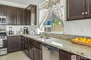 Indio house for rent - A kitchen with dark brown cabinets and granite countertops.