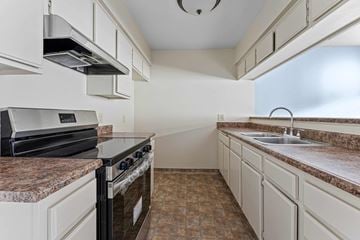Burbank apartment for rent - A kitchen with a black stove top oven and a granite counter top.