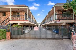 Burbank apartment for rent - A gated entrance to a brick apartment complex.