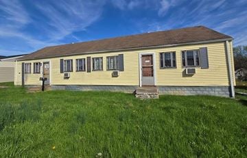 Charlestown house for rent - A yellow house with a brown roof and a brown door.