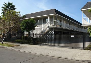 Burbank apartment for rent - A black house with a white fence and a tree in front.