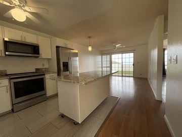 Kapolei apartment for rent - A kitchen with white cabinets and a marble island.