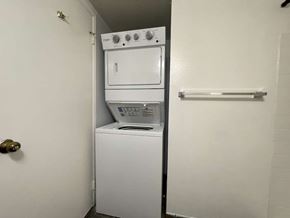 Kapolei apartment for rent - A white dryer and washer are stacked on top of each other in a small laundry room.