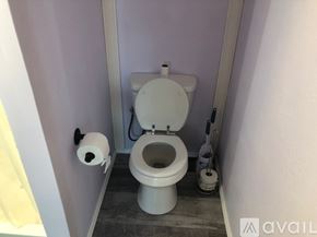 Hillsboro apartment for rent - A white toilet in a small bathroom with a roll of toilet paper on the wall.