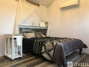 Hillsboro apartment for rent - A bedroom with a bed, nightstand, and a window with curtains.