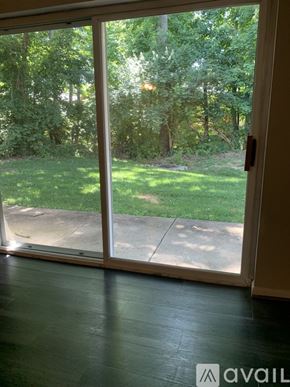 Cincinnati apartment for rent - A sliding glass door with a view of a green lawn and trees.