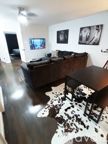 St. Louis house for rent - A living room with a brown couch and a cowhide rug.