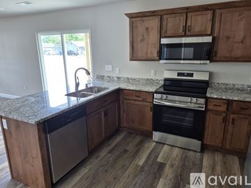 Webb City house for rent - A kitchen with wooden cabinets and a granite countertop.