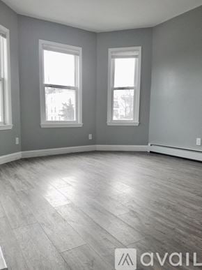 Boston apartment for rent - A room with grey walls and wooden flooring with two windows.