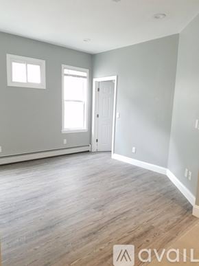 Boston apartment for rent - A room with wooden flooring and a door leading to another room.