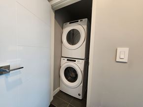 Edmonton apartment for rent - A white washing machine is in a small space.