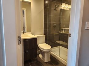 Edmonton apartment for rent - A white toilet sits in a bathroom next to a walk-in shower.