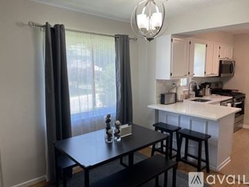 Hyattsville apartment for rent - A kitchen with a table and chairs in front of a window with curtains.