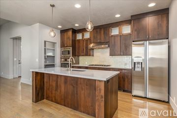 Boise house for rent - A kitchen with wooden cabinets and a white countertop.