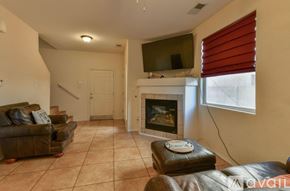 Albuquerque house for rent - A bedroom with a bed, a ceiling fan, and a window with blinds.