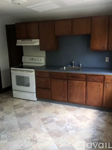 Wallingford apartment for rent - A kitchen with a white stove and brown cabinets.