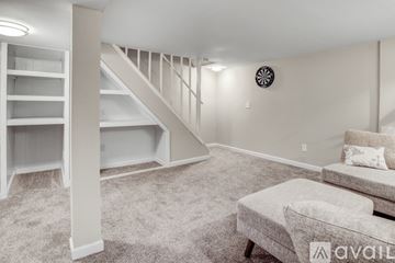Saint Charles house for rent - A living room with a grey couch and a white staircase.