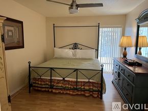 Sarasota condo for rent - A bedroom with a four poster bed and a dresser.