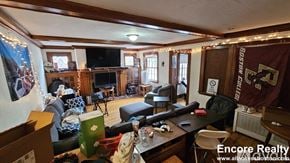 Boston house for rent - A living room with a Boston College banner on the wall.