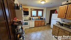 Boston house for rent - A kitchen with a refrigerator, microwave, oven, and dishwasher.