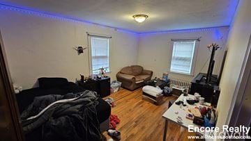 Boston house for rent - A living room with a couch, chair, and a table with various items on it.