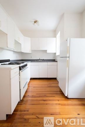 Brookline apartment for rent - A kitchen with white appliances and wooden floors.
