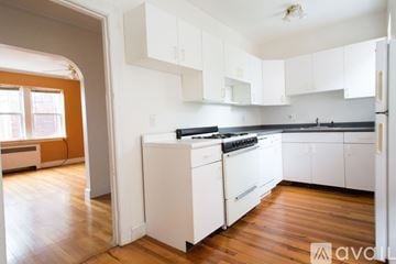 Brookline apartment for rent - A kitchen with white cabinets and a black stove top oven.