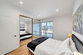 West Hills house for rent - A bedroom with a large bed and a mirrored doorway leading to a balcony.
