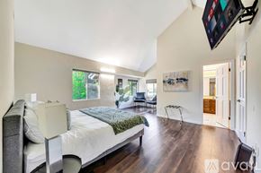 Agoura Hills house for rent - A bedroom with a large bed and a flat screen TV mounted on the wall.