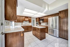Agoura Hills house for rent - A kitchen with wooden cabinets and a white refrigerator.