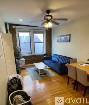 Boston apartment for rent - A living room with a blue couch and a ceiling fan.
