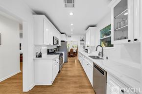 Los Angeles house for rent - A modern kitchen with white cabinets and stainless steel appliances.