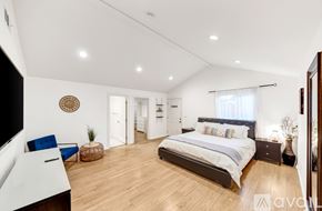 Los Angeles house for rent - A bedroom with a large bed and a blue chair.