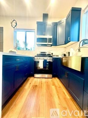 Los Angeles house for rent - A kitchen with dark blue cabinets and a wooden floor.