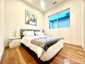 Los Angeles house for rent - A bedroom with a large bed and a painting on the wall.