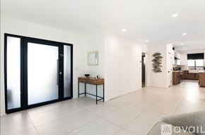 Los Angeles house for rent - A modern kitchen with a table and chairs in the middle of the room.