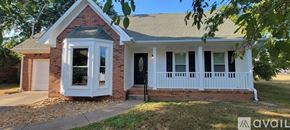 Clarksville house for rent - A small house with a black door and a garage door.