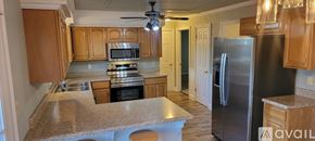 Clarksville house for rent - A room with a carpeted floor, a ceiling fan, and a view of a street through the windows.